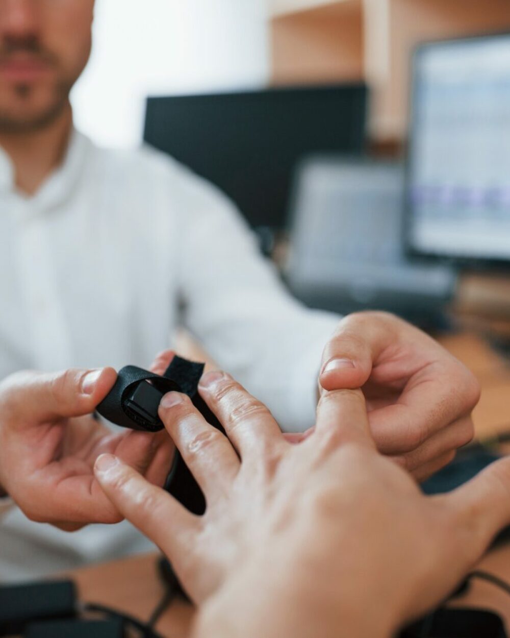 A professional polygraph examiner conducting a lie detector test on a seated individual.